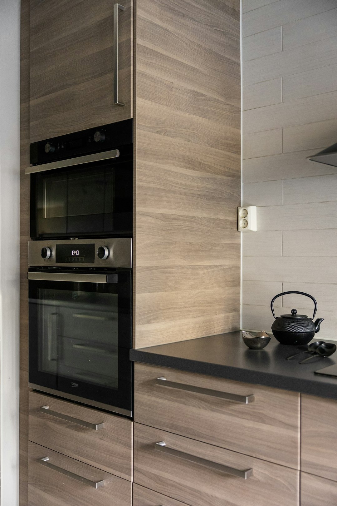 Modern kitchen with wood cabinetry and organized countertop accessories.